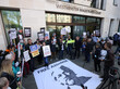 Protestierende Menschen mit Plakaten vor dem Westminster Magistrates Court in London.