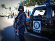Ein ägyptischer Polizist steht in voller Montur und mit Gewehr vor einem dunklen Polizeifahrzeug
