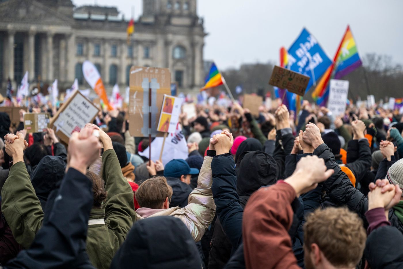 Demonstration vor dem Reichstag in Berlin mit erhobenen Fäusten und Schildern