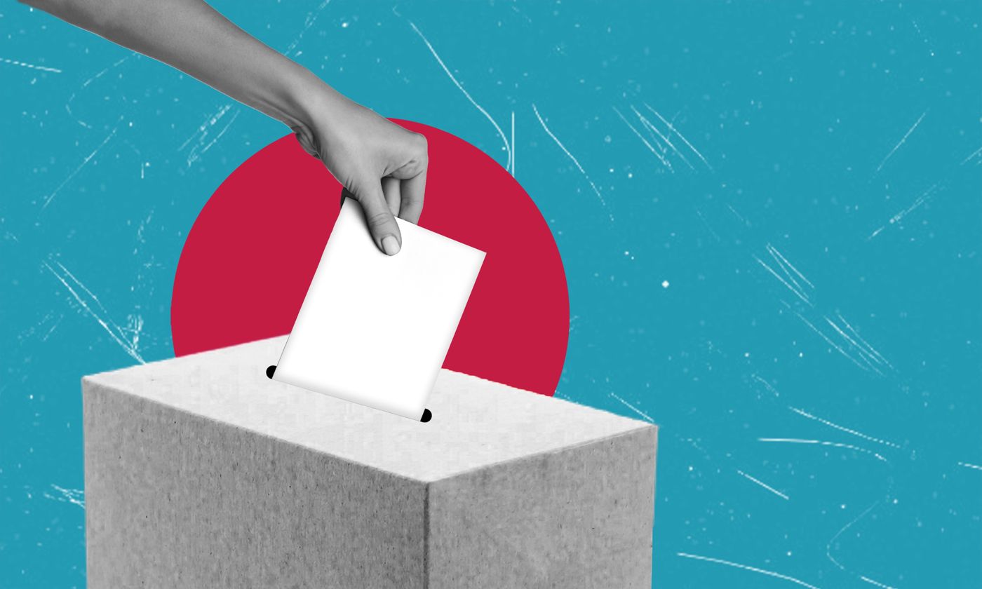 Eine Hand wirft einen Stimmzettel in eine Wahlurne