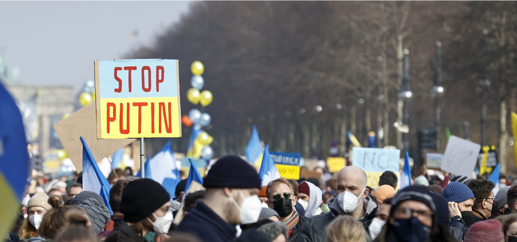 Person hält "Hands Off Ukraine"-Plakat.