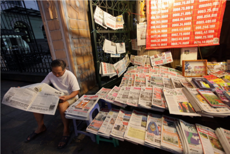 Eine Person liest Zeitung an einem Zeitungsstand in Hanoi 