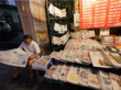 Eine Person liest Zeitung an einem Zeitungsstand in Hanoi 