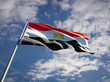 Die Nationalflagge Ägyptens (erst ein roter, dann ein weißer und zuletzt ein schwarzer Querstreifen; auf dem weißen Streifen ist mittig ein goldener Adler zu sehen) weht vor dme Himmel