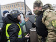 Ein Journalist mit Presse-Helm spricht auf einer Nawalny-Demonstration mit einem Mann in militärischer Uniform