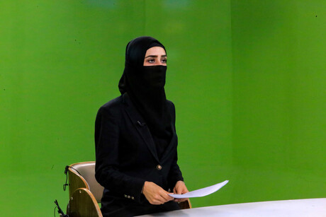 Die afghanische Fernsehjournalistin Lema Spasli moderiert für den privaten Sender 1 TV vor einem Greenscreen - auf Anordnung der Taliban verhüllt.