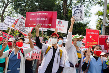 Demonstrierende in Yangon halten Plakate und Schilder hoch, auf denen u.a. Aung San Suu Kyi zu sehen ist und #SaveMyanmar steht