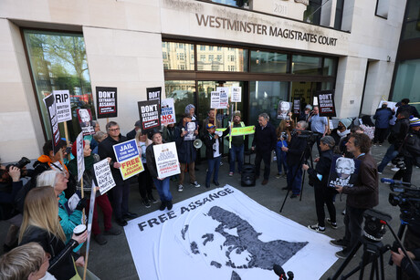 Protestierende Menschen mit Plakaten vor dem Westminster Magistrates Court in London.