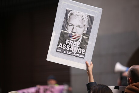 Eine Hand hält ein Plakat mit dem Gesicht von Julian Assange hoch. Auf dem Plakat steht: "Free Assange. No U.S. Extradition."