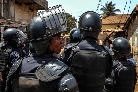 Polizeibehörden in schwarzer Einsatzkleidung stehen dicht an dicht