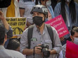 Ein Mann mit Helm und Maske hält eine Kamera in den Händen.