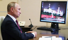 Russlands Präsident Vladimir Putin sitzt am Schreibtisch.