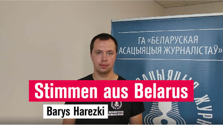 Belarusischer Journalist vor Plakat