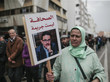 Eine Frau in Marokko trägt ein Schild mit dem Bild von Taoufik Bouachrine und der Aufschricht "Journalismus ist kein Verbrechen".