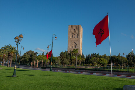 Ein Turm, im Vordergrund eine rote Flagge.