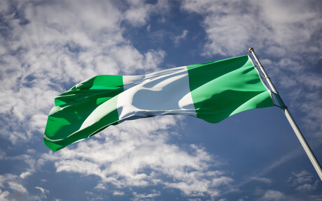 Die Nationalflagge Nigerias (erst ein dunkelgrüner, dann ein weißer und dann noch ein dunkelgrüner senkrechter Balken) weht im Wind