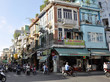 Straßenecke mit Läden und Personen auf Rollern in Ho-Chi-Minh-Stadt