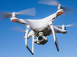 Eine weiße Drohne mit vier Propellern und Überwachungskamera.