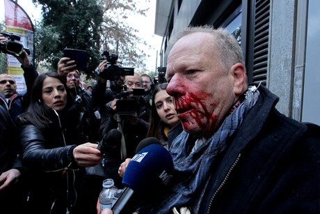 Journalist Thomas Jacobi spricht mit blutüberströmtem Gesicht in Mikrofone und Kameras