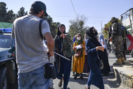 Ein Taliban-Vertreter geht mit ausgestrecktem Zeigefinger auf den Fotografen des Bildes zu, daneben sind mehrere Demonstrierende zu sehen. © Bülent Kilic / AFP