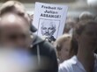 Auf einer Demonstration in Aachen fordern Demonstrierende Freiheit für Julian Assange, dazu hält eine Person ein Schild mit diesem Spruch und einem Foto von Assange.