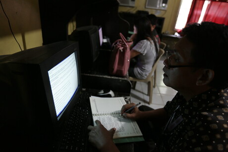 Zu sehen ist ein Journalist vor einem Computer in einem Redaktionsraum auf den Philippinen. © picture alliance / dpa | Rolex Dela Pena