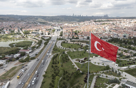 Blick auf eine Stadt, im Vordergrund weht die türkische Flagge