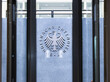 Auf dem Bild ist eine Glastür abgebilet, durch die Tür sieht man das metallene Logo des Bundesnachrichtendienstes. 