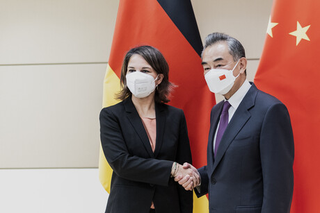 Beide stehen händeschüttelnd vor den Flaggen ihrer jeweiligen Länder, sie tragen dabei Atemschutzmasken, da das Foto vom September 2022 stammt.