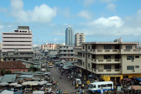 Stadtansich von Cotonou mit einem Markt auf der linken Seite und vielen Gebäuden