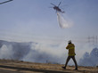 Fotograf fotografiert einen Hubschrauber, der mit Wasser die Waldbrände bekämpft.