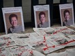 Drei Porträtfotos einer Frau stehen auf dem Boden, davor Zeitungspapier.