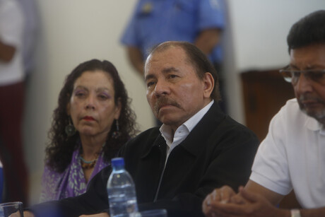 Daniel Ortega sitzt zwischen zwei Personen.