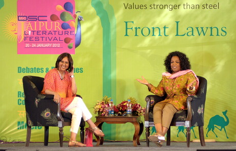 Zwei Frauen sitzen auf einer Bühne.