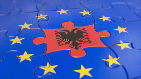 Die albanische Flagge ist in einem Puzzle umgeben von europäischen Sternen zu sehen. 