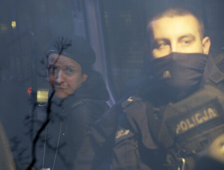 Agata Grzybowska sitzt links neben einem Beamten in einem Polizeiauto