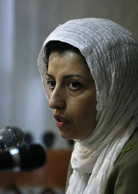 Portrait von Narges Mohammadi die in ein Mikrofon spricht.