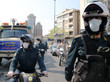 Iranische Polzeibehörden auf Motorrädern und in einem Polizeiwagen