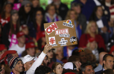 Mann mit "Make America great again"-Kappe hält ein Schild hoch auf dem u.a. The New York Times und CNN als "Fake News" bezeichnet werden