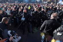 Polizisten stehen während der Demonstration der Stuttgarter Initiative „Querdenken“ auf dem Augustusplatz vor Gegendemonstranten.
