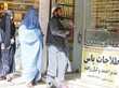Verhüllte Frauen und ein traditionell afghanisch gekleideter Mann nach der Machtübernahme der Taliban.