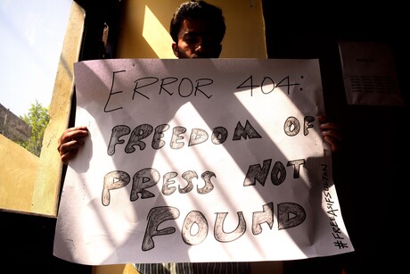 Ein junger Mann hält ein selbst gemaltes Plakat in die Höhe auf dem steht: "Error 404 Freedom of Press not found!"