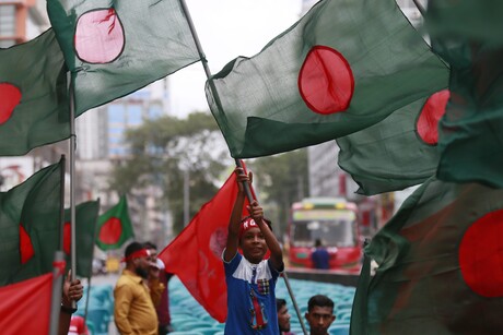 Menschen schwingen die bangladeschische Nationalflagge (ein roter Punkt in der Mitte auf dunkelgrünem Grund)