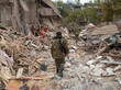 Zwei Personen laufen durch die Trümmer zerstörte Häuser in Stepanakert in Bergkarabach. 