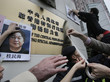 Demonstrierende hängen Bilder von Gui Minhai und anderen Entführten an das chinesische Verbindungsgebäude