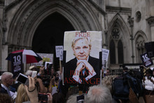 Menschen halten Protestschilder. Auf einem steht: "Free Julian Assange"