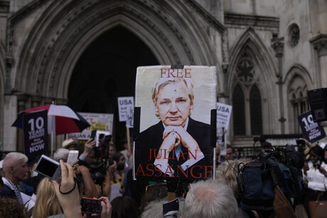 Menschen halten Protestschilder. Auf einem steht: "Free Julian Assange"