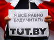 Eine Person hält ein Blatt, auf dem in kyrillischer Schrift steht: "Ich werde trotzdem weiter tut.by lesen"