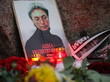 Blumen und Kerzen neben einem Porträt der russischen Journalistin Anna Politkowskaja am Solowezki-Stein in Russland.