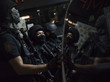 Drei schwarz gekleidete und schwer bewaffnete Sicherheitskräfte stehen nebeneinander